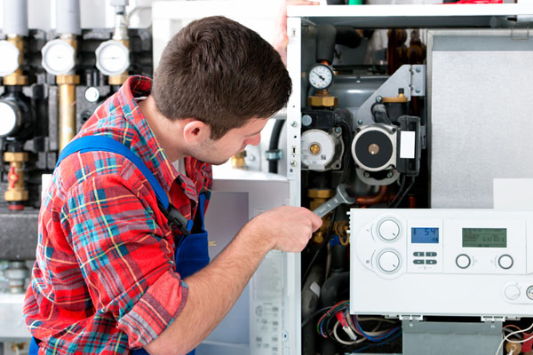 HVAC technician inspecting and repairing boiler controls in Lafayette