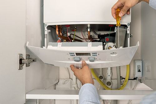HVAC technician repairing an indoor boiler in Lafayette