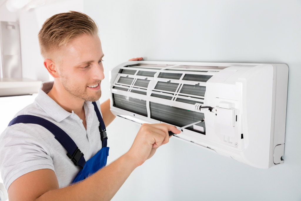 HVAC technician performing ductless air conditioning maintenance in Lafayette