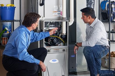 65df8c11f3e4c468cbd351a5_furnace repair vs replacement – Copy HVAC technician explaining furnace repair and maintenance to a homeowner in Lafayette, CO