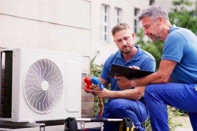 ac-installation-in-claremont-ca HVAC technicians reviewing an outdoor air conditioning unit in Lafayette, CO