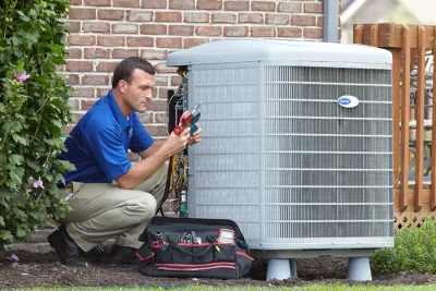 design-air-heating-and-air-conditioning-decatur-il-05 – Copy HVAC technician inspecting an outdoor air conditioning unit in Lafayette, CO