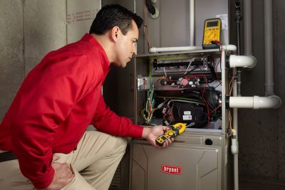 furnace repair Heating and air conditioning technician servicing an indoor furnace in Lafayette, CO